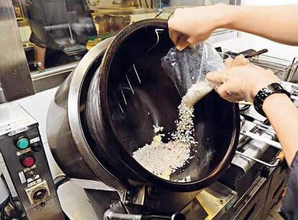 麵店的獨門炒飯機,放蛋和飯後,高溫極速炒飯,以攝氏 240 度將飯粒炒香,而其螺旋傾斜設計可減少炒飯時水份流失。(麵座) 香港